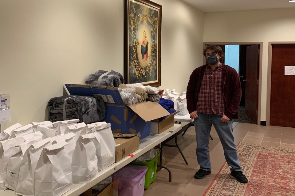 SLU student Andrew Sweeso, president of SLU’s St. Benedict Labre Ministry with the Homeless, stands with donations for people experiencing homeless as part of the Catholic Studies Centre's care package night.