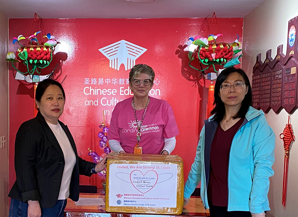 SLU professor Donghua Tao, Ph.D. (right) joins another volunteer and a staff member from SSM Health Cardinal Glennon Children's Hospital, to present donations of PPEs from St. Louis's Chinese-American community.