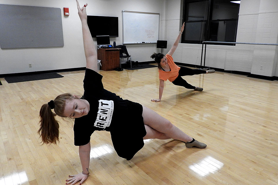 Alumna Molly Meyer (A&S '18) (front) and sophomore Reed McLean (back) stretch as part of a Make Dark Days Brighter movement class.