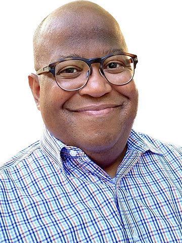 A portrait photo of Daniel Blash smiling and wearing glasses