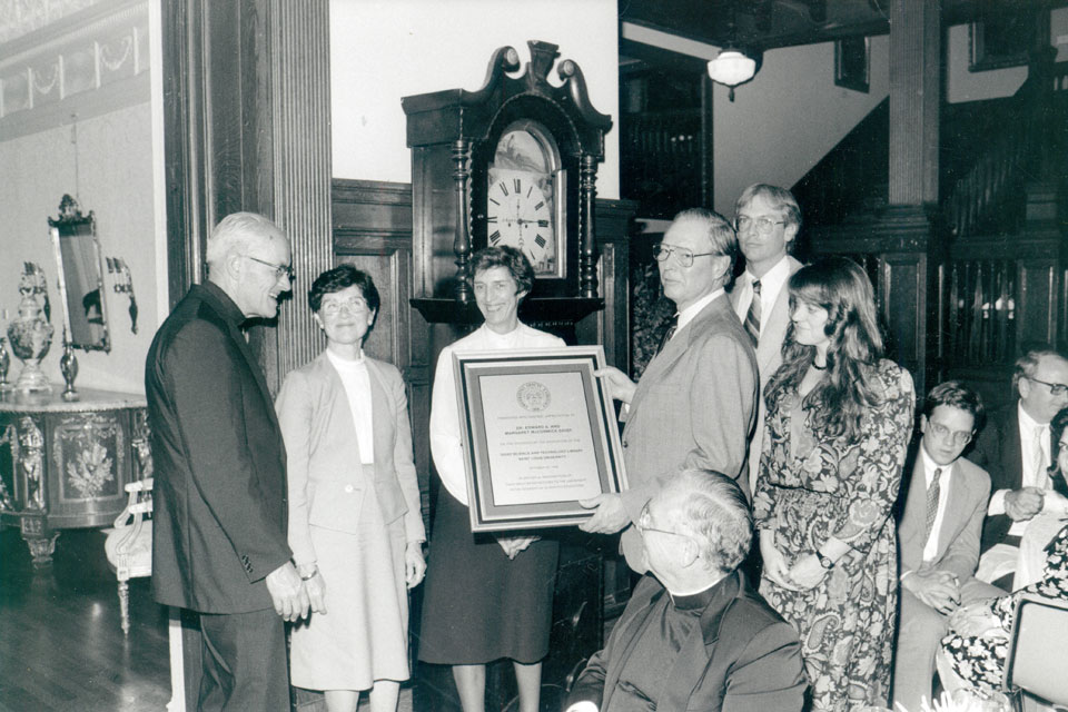 Edward A. Doisy, Ph.D. (holding plaque at right) gathers with his family and SLU leaders to receive an honor.