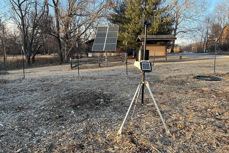 A SLU weather sensor sits on a tripod in a field to collect data to share with local organizations.