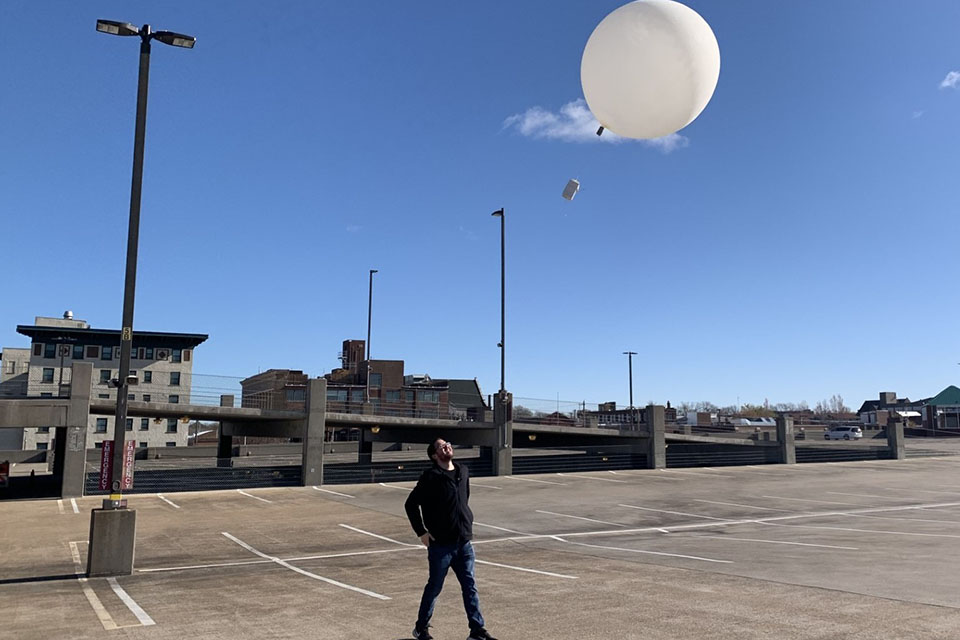 Students prepare for the 2024 solar eclipse by practicing their weather balloon release on the roof of the Olive Compton Garage. 