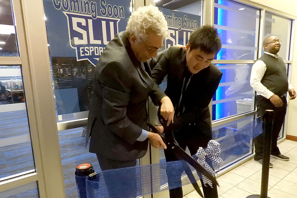University President Fred P. Pestello, Ph.D., and Nicholas Chiu, director of esports, cut the ribbon to open SLU's new Esports Gaming Lab.