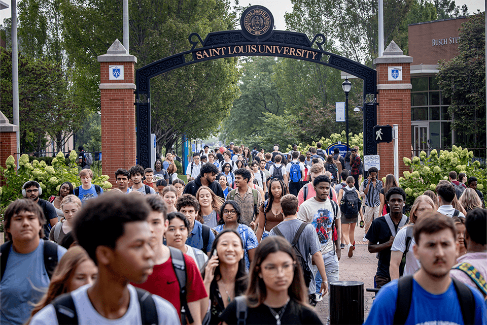 Students walk to class on a sunny day on Saint Louis University's campus.