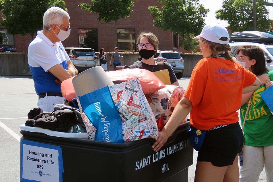 SLU President Fred P. Pestello, Ph.D., left, greets a new student during Move-In Thursday, Aug. 19, 2021. Photo by Joe Barker.