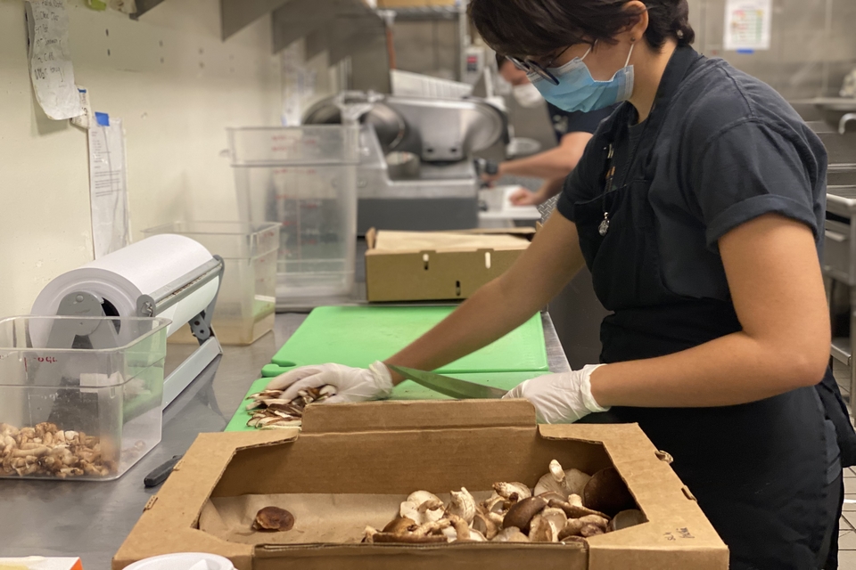 Student Sophie Santangelo chops mushrooms as Fresh Gatherings prepares to re-open with new social distancing and safety measures in place.