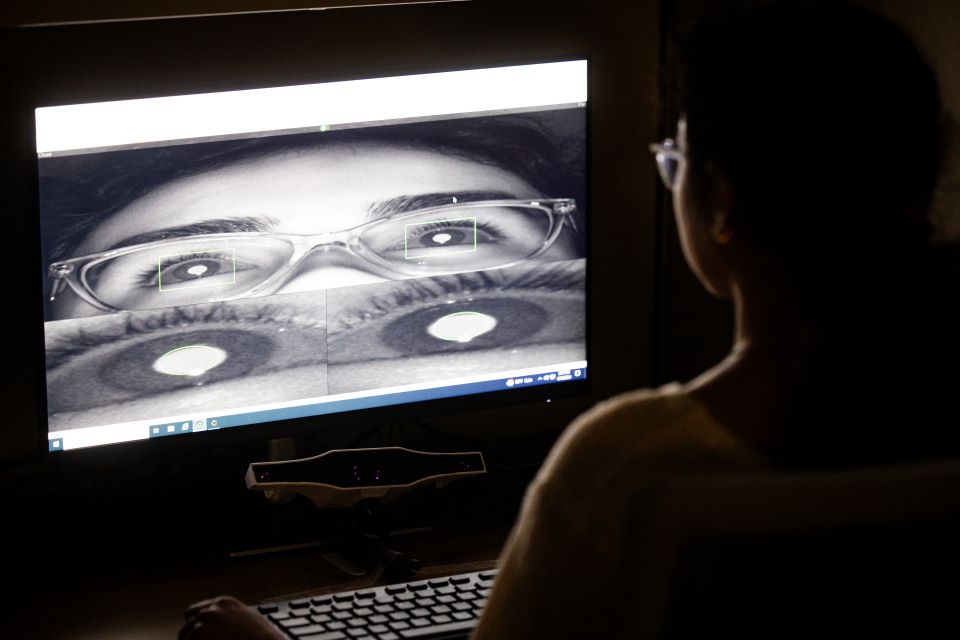 A female student tries out innovative eye-tracking equipment. 