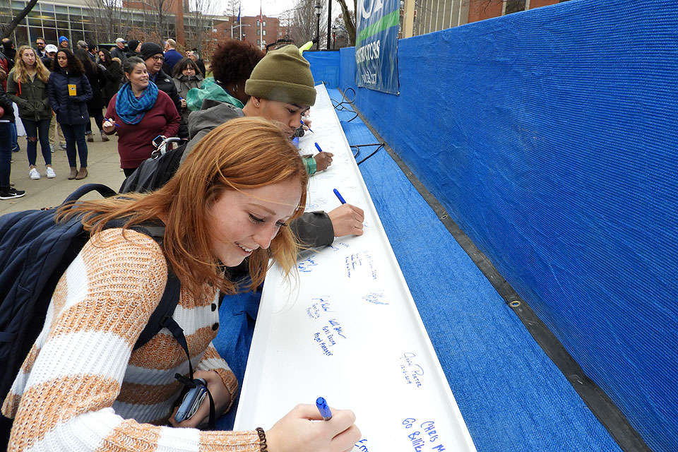 Students sign the beam to top out SLU's new ISE Building.