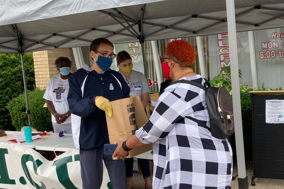 Noah Apprill-Sokol, a student at Saint Louis University High School and future Billiken, distributes bags of face masks to a member of the Jennings Clergy Coalition at the Aug. 1 PPE drive. Submitted photo