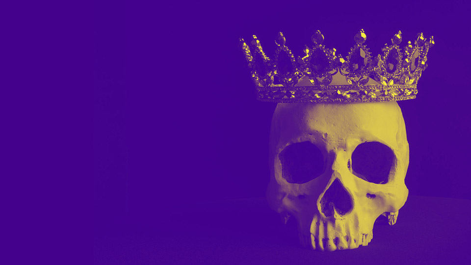 A gold skull wearing a crown on a purple background