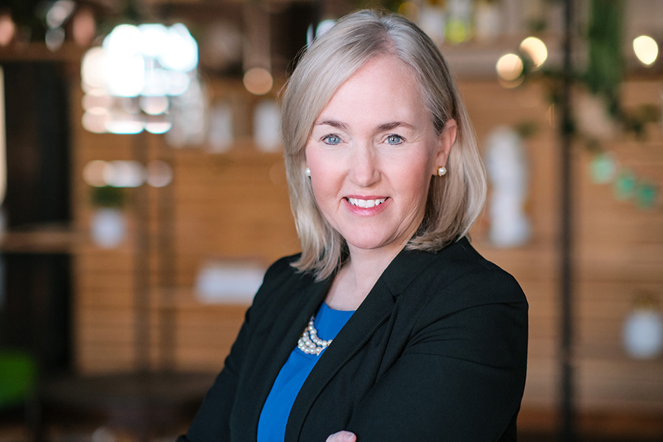 A photo of Dr. Kristine L’Ecuyer. She wears a dark-colored blazer and smiles at the camera.