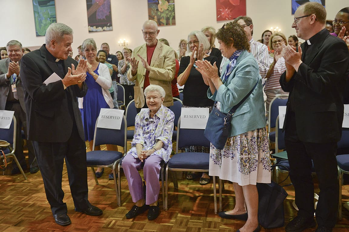 SLU alumna and legend Mary Bruemmer (seated, center) receives a papal knighthood from St. Louis Archbishop Robert Carlson (right) to the applause of the University community in 2016. 