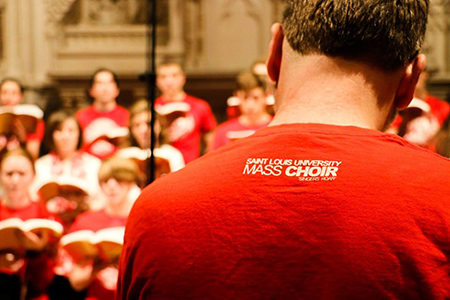 The SLU Mass choir with a back view of a choir member's shirt.