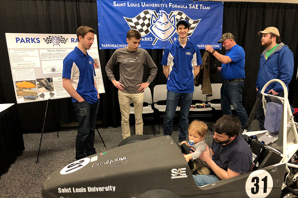 A future Billiken gets a feel for the controls in the Parks Racing Club's car at the St. Louis Auto Show.