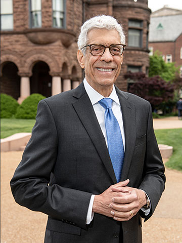 SLU President Dr. Fred P. Pestello posing in front of Cupples House on SLU's campus. 