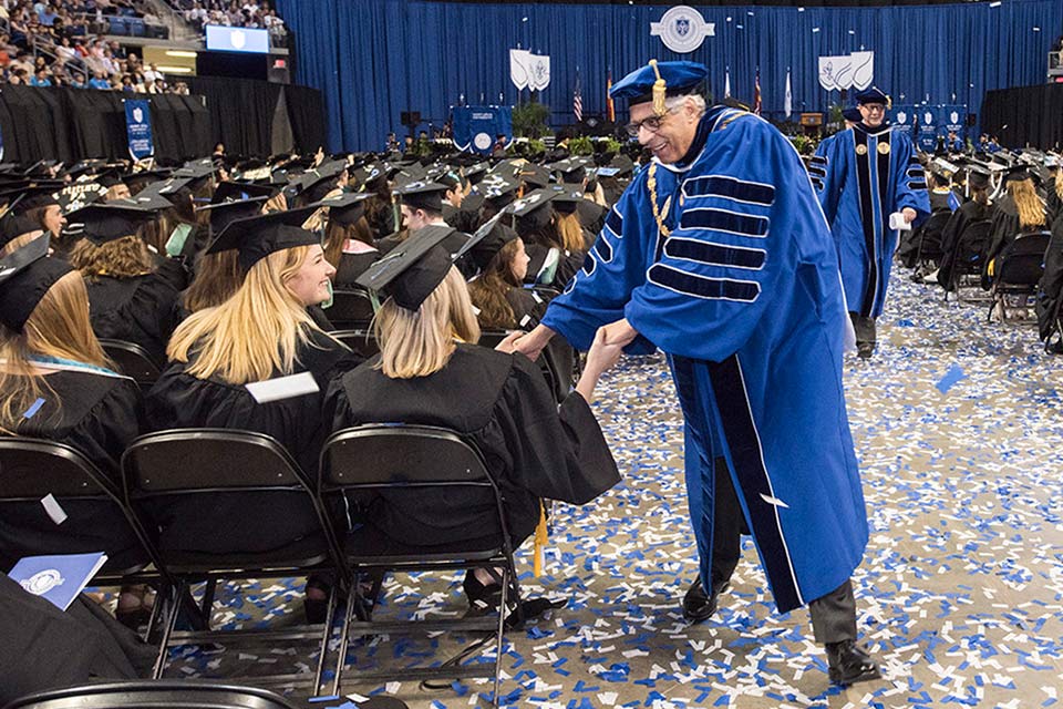 Dr. Pestello greets students at commencement