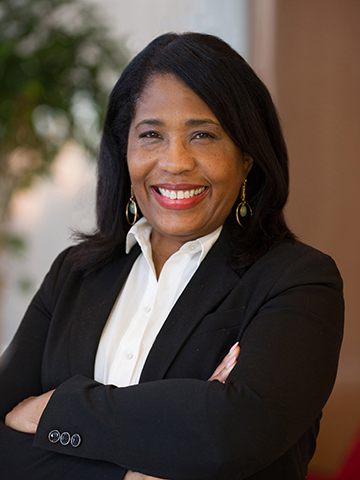A posed portrait of Rochelle D. Smith smiling with her arms crossed.