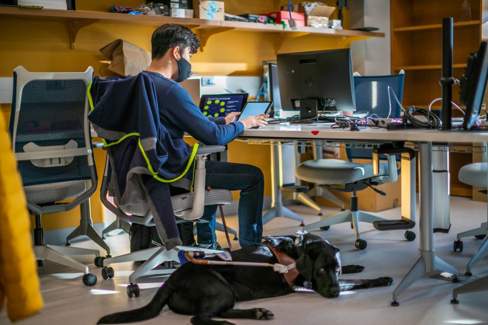 Seyoon Choi is pictured here with his service dog in SLU's CHROME Lab. Photo by Garrett Canducci.  