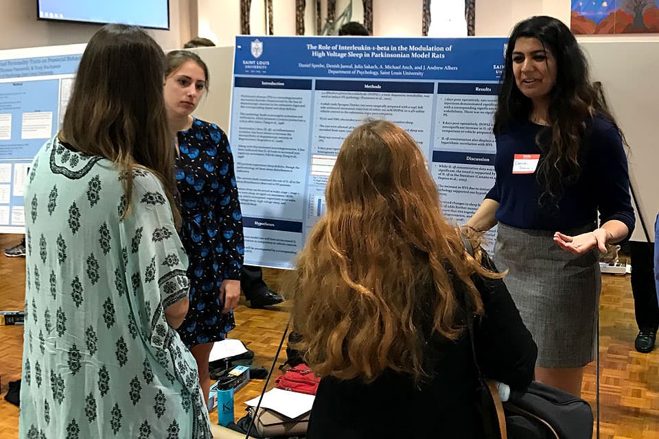 Students present a poster about their research.