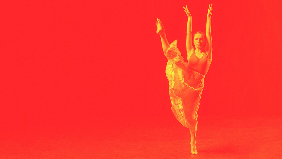 A gold dancer against a red backdrop