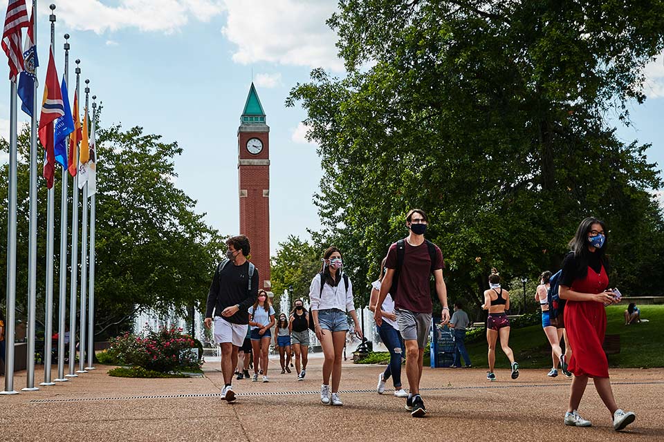Students follow SLU’s face mask requirements while walking near the clock tower on the first day of fall classes. 