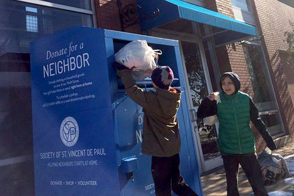 People donate to the St. Vincent de Paul Society using a bin near the Olive-Compton Garage.