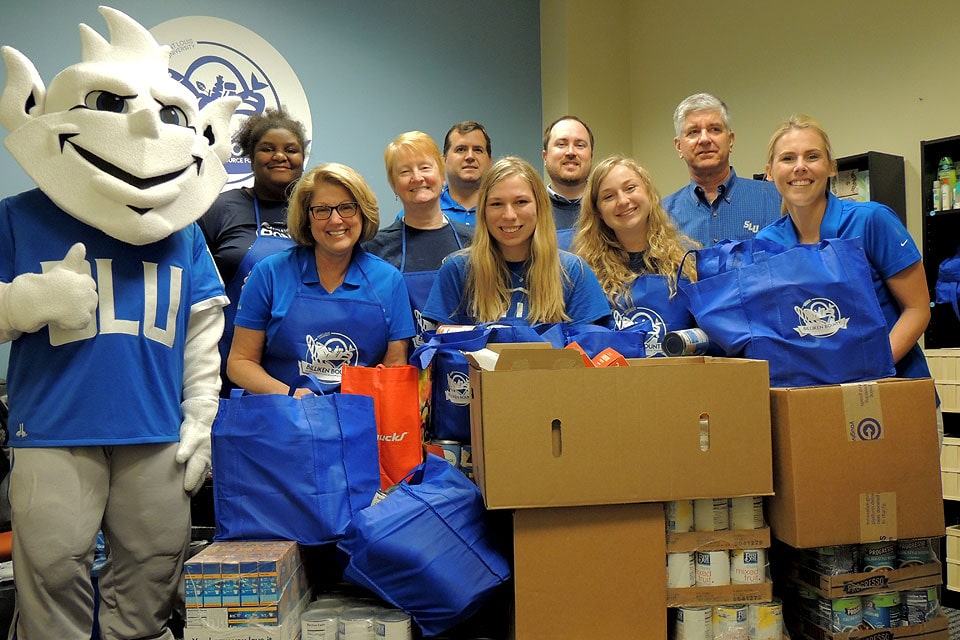 A group donates canned goods to Billiken Bounty.