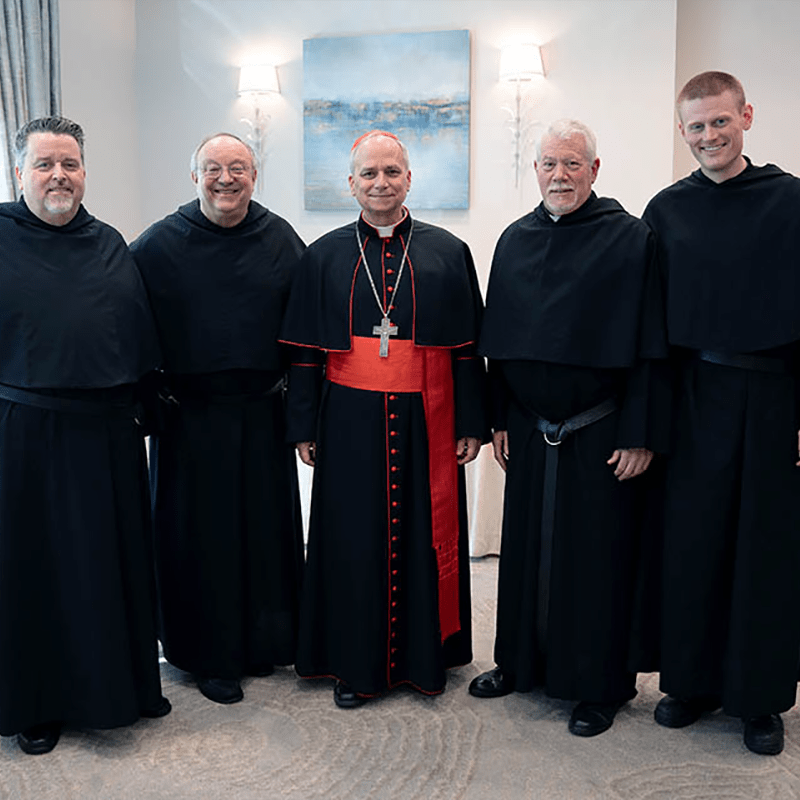 Four friars stand on each side of Pope Leo. 