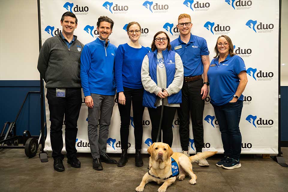 Wood, SLU's newest facility dog, is surrounded by his handlers during his graduation to become an official facility dog. 