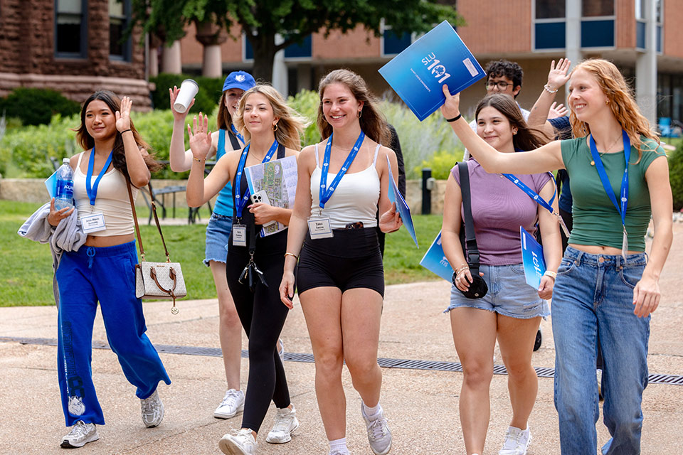A group of young adults tours Saint Louis University's campus.