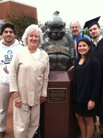 The Milburn family with the Billiken statue