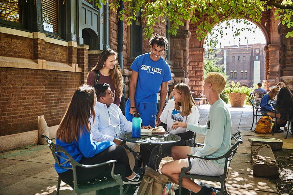 SLU students socializing on a sunny patio