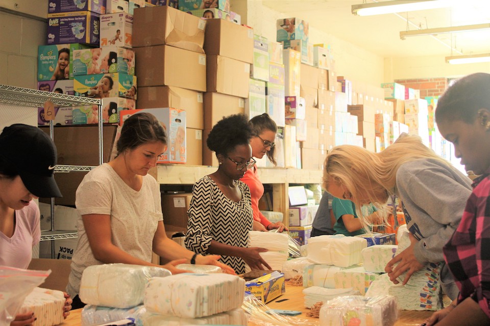 Students organize diapers into packets to be distributed in the St. Louis region.