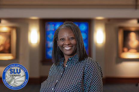 A headshot of Christa Jackson, Ph.D., and the SLU Research Institute Fellows induction coin.