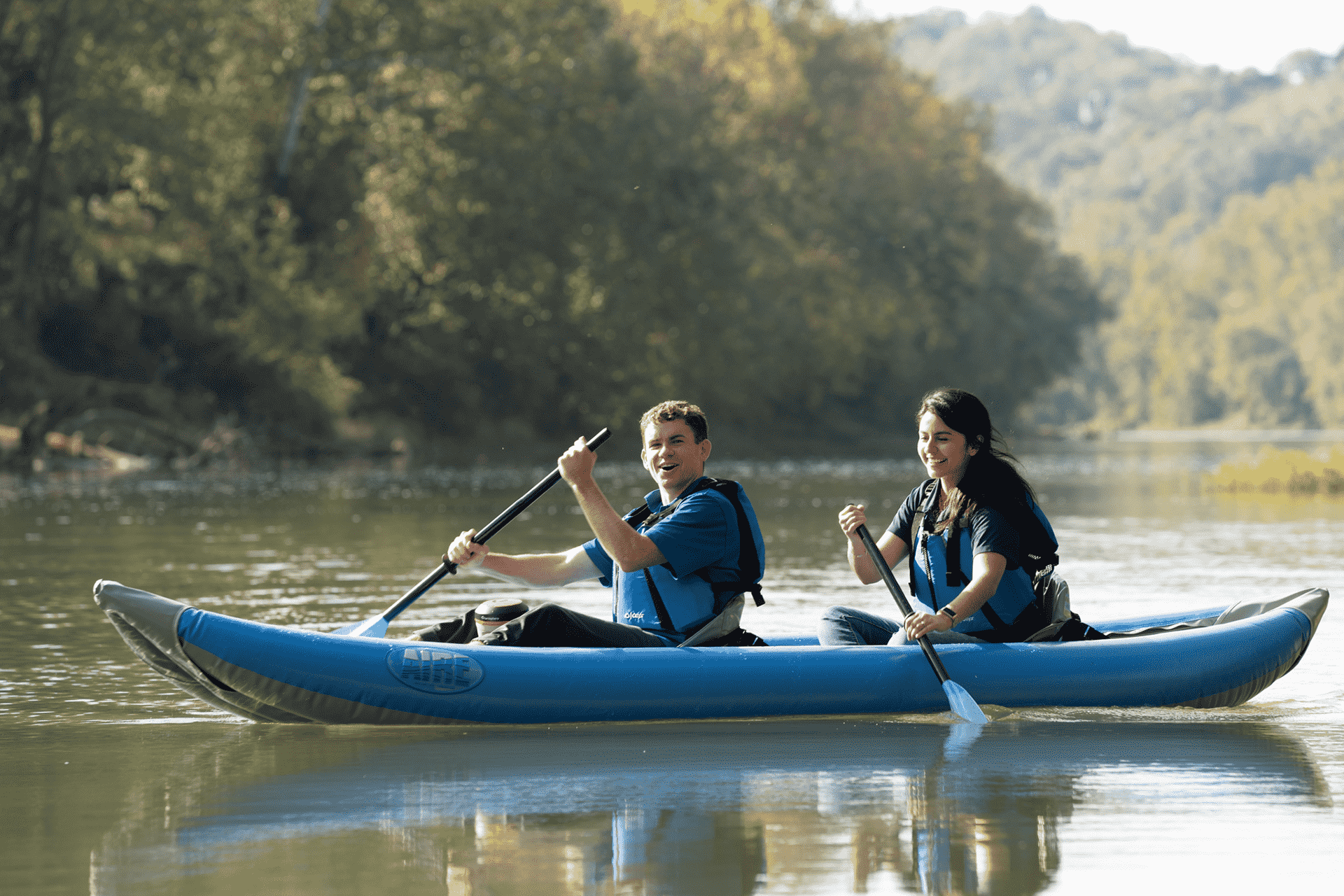 main picture of two people paddling in a canoe on a lake