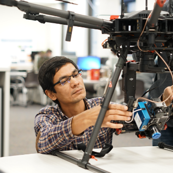 A student works with a drone in the Remote Sensing Lab at SLU