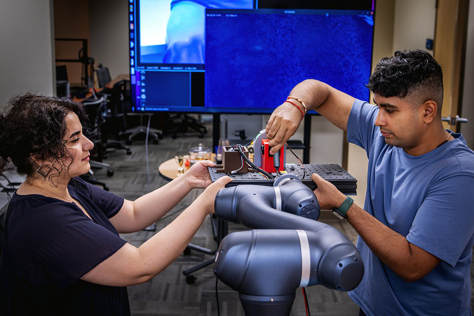 Airlab robotics work Graduate student researchers in the AIRLab work together to integrate and calibrate a custom sensing platform on an industrial robotic arm.