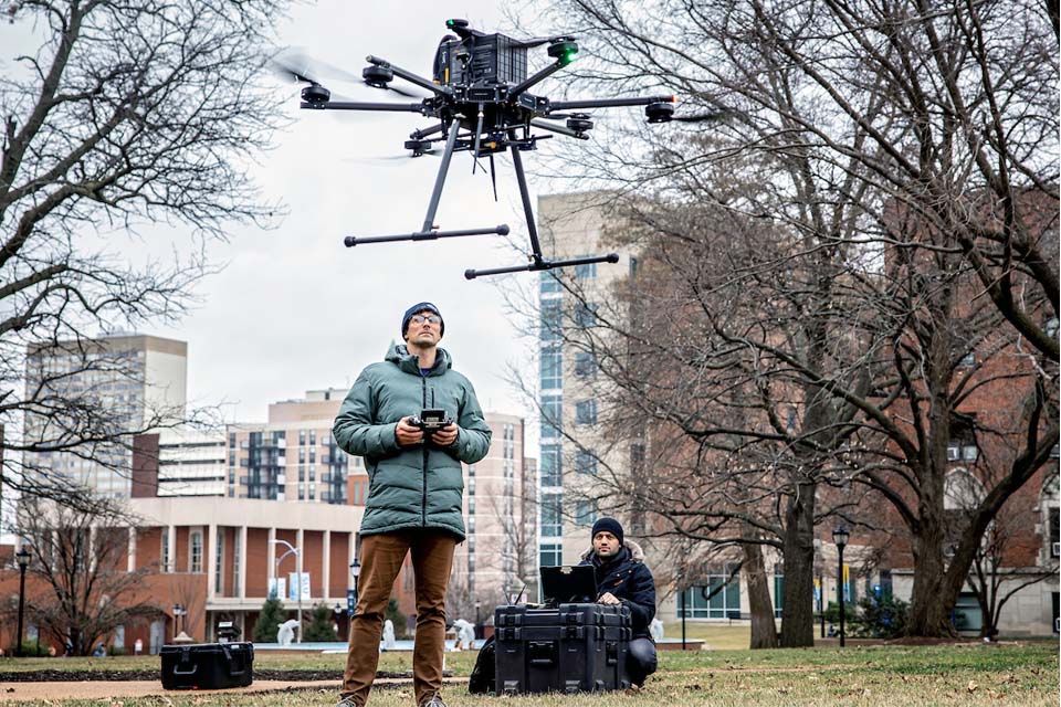A person controls a drone as it flies into the air.