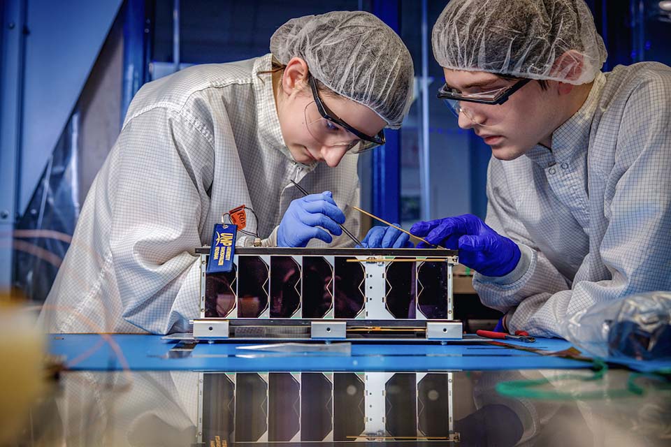 Space Systems Research Lab Two students work on a cube satellite in the Space Systems Research Lab