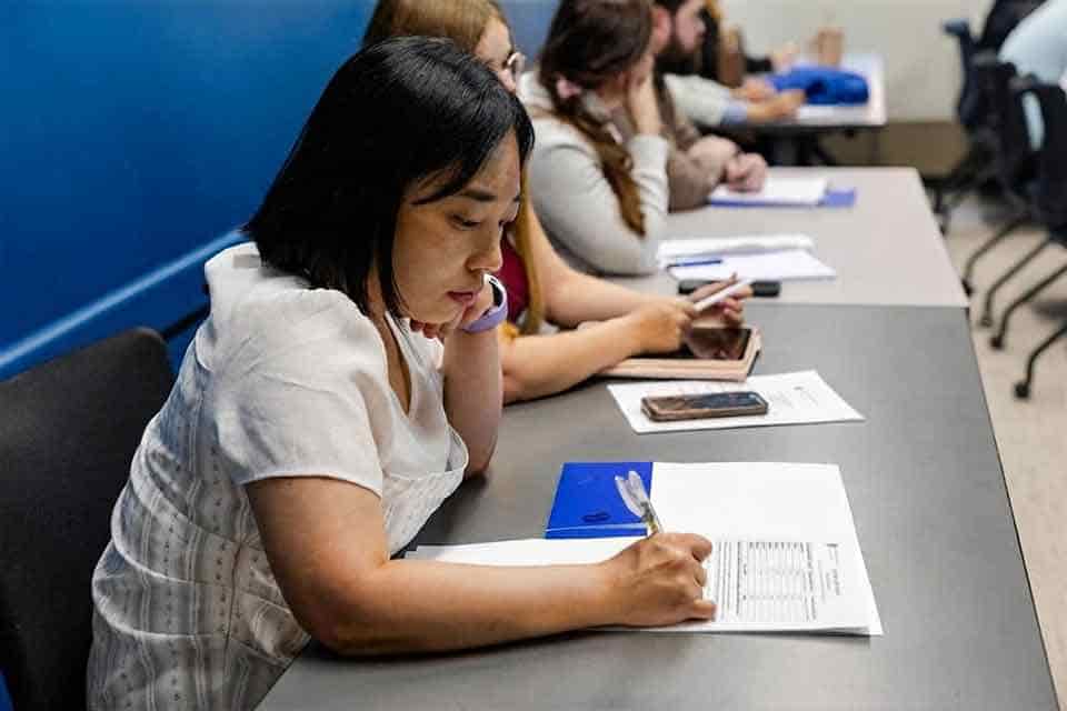 A student completes paperwork in a classroom.