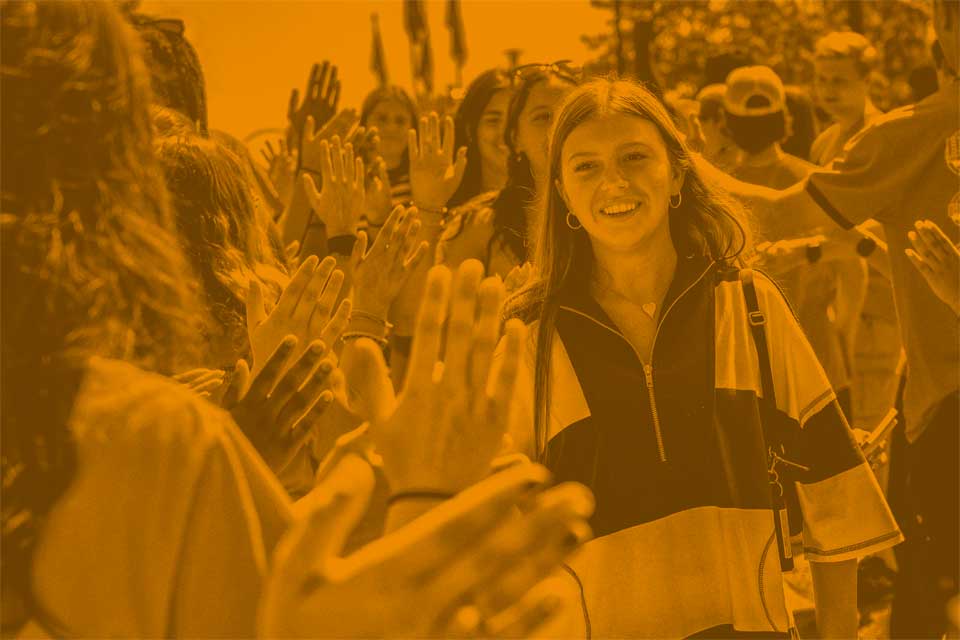 A new SLU freshman student high fives returning student during the 2026 Convocation.