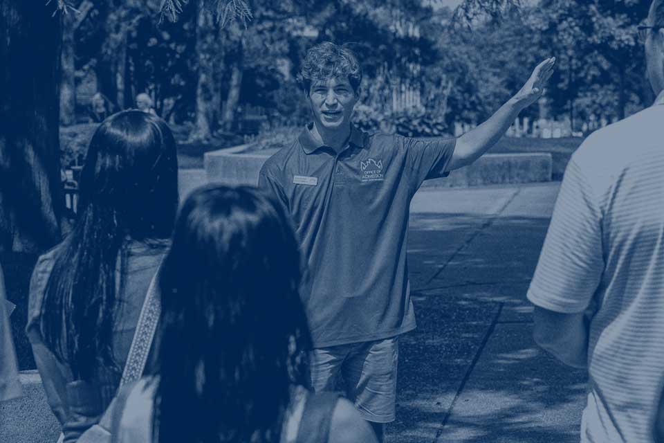 A SLU Campus Ambassador leads a group of parents and students on a tour of campus.
