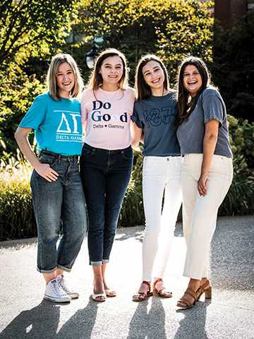 Four female members of Delta Gamma Connections stand together on campus.