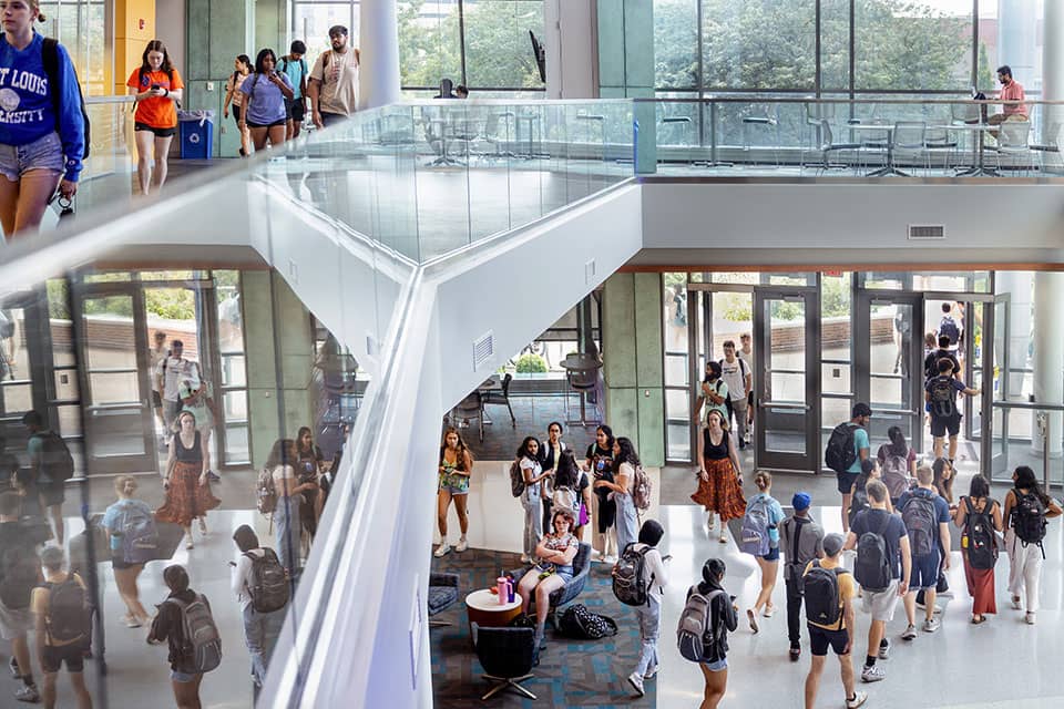 A birds-eye view of the entrance of the Sinquefield Science and Engineering Center. Students walk in and out of the building on their way to class
