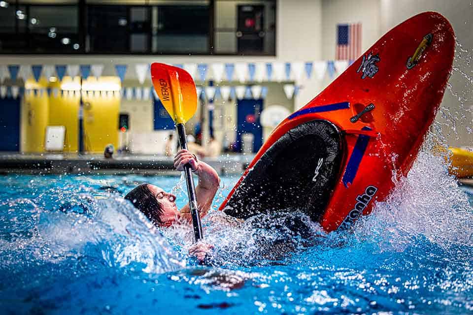 SLU Club Sports A kayaker nearly flips in their kayak while practicing in a SLU pool