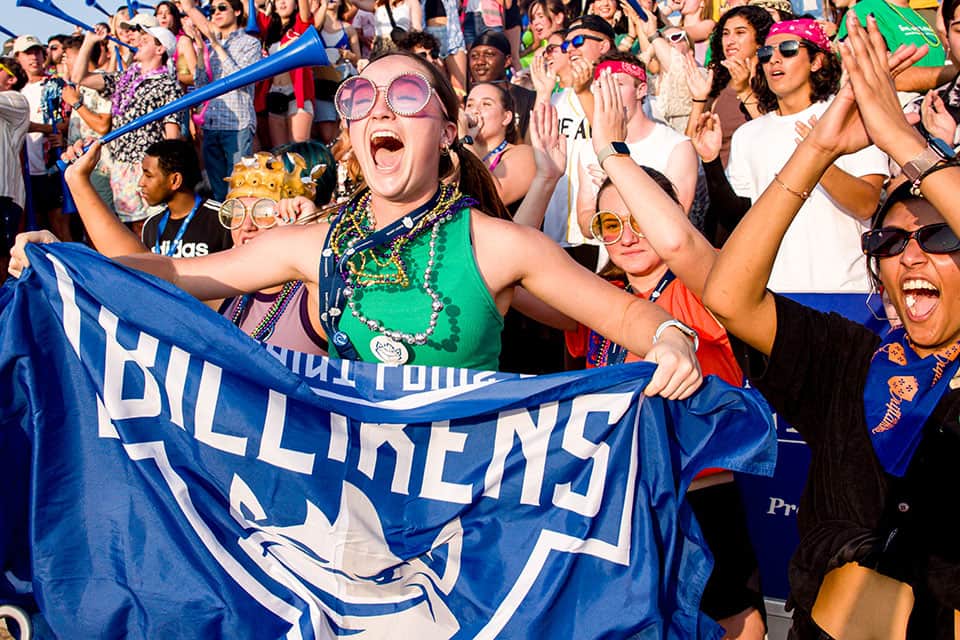 A student holds up a Billiken Athletics flag during a spirit celebration 