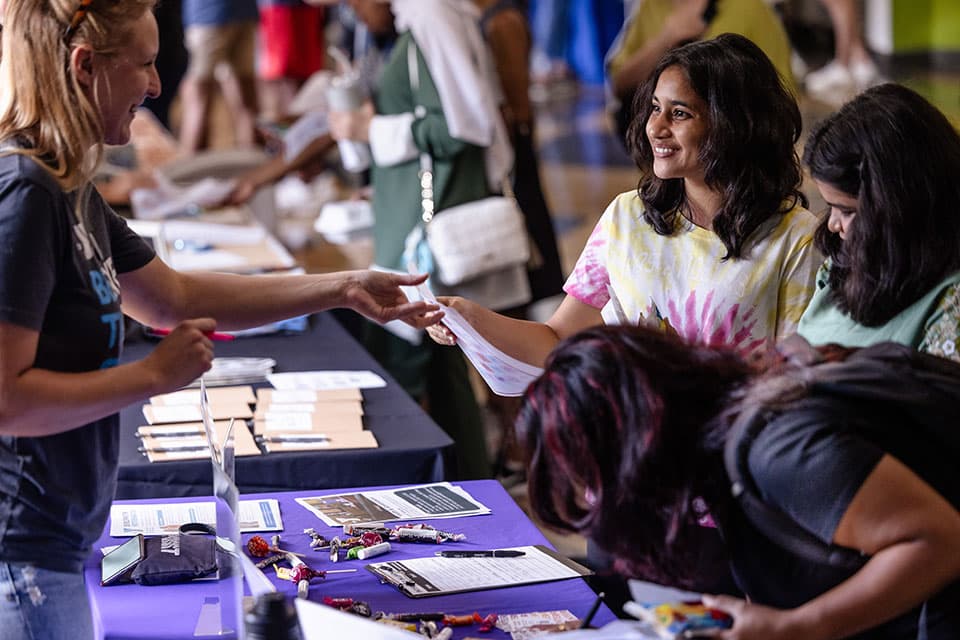 Students chat with a student organization representative at the Community Service Fair