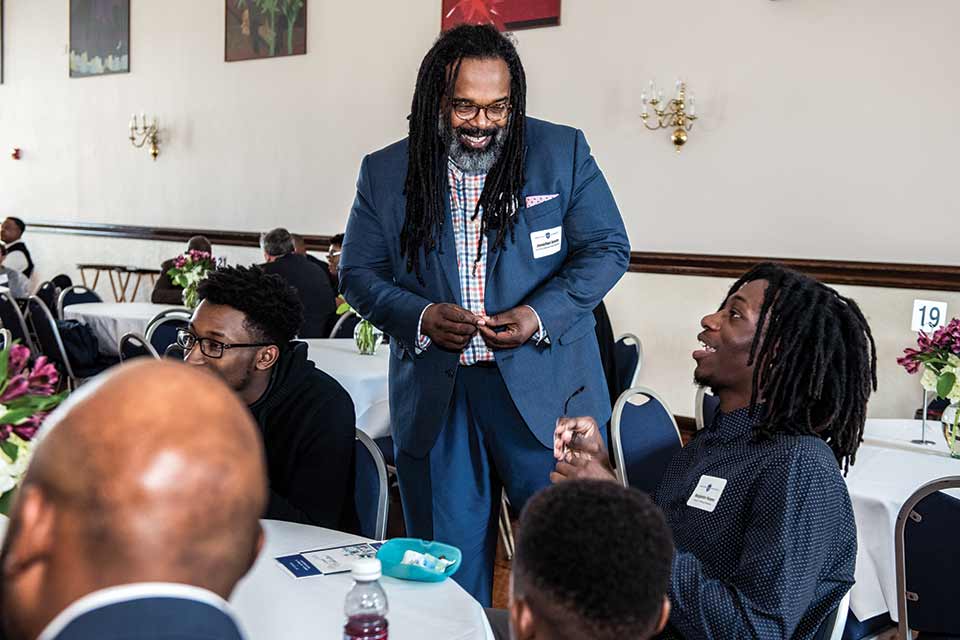 Dr. Jonathan Smith smiles as he speaks with a student at an event.