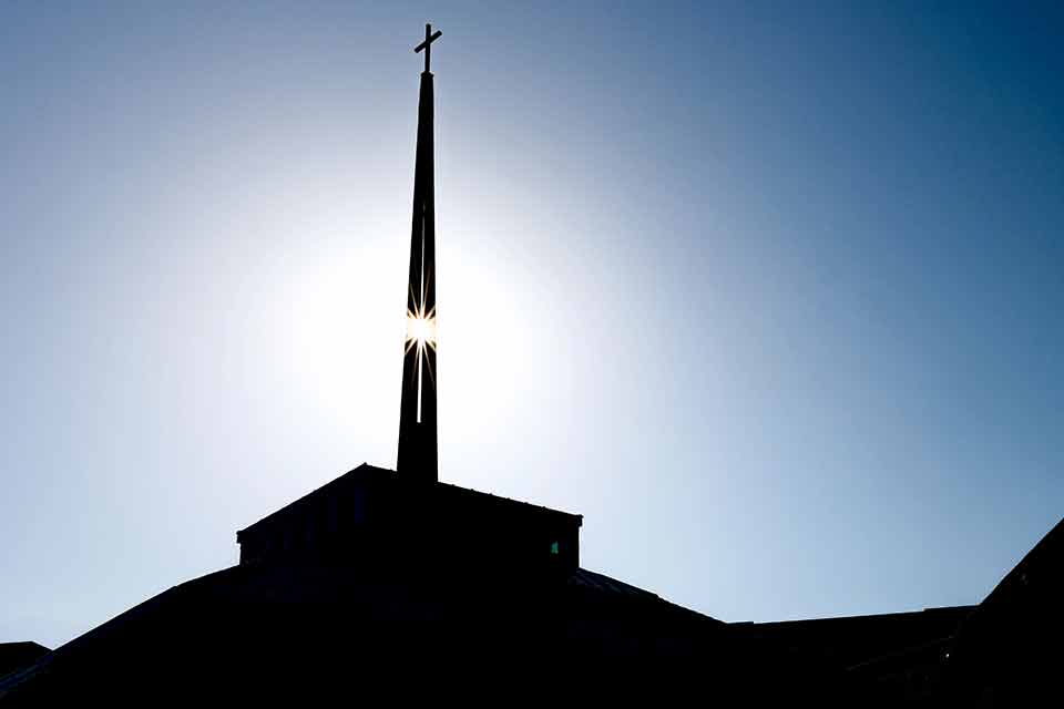 The sun shines through the steeple of SLU's Jesuit Center. 